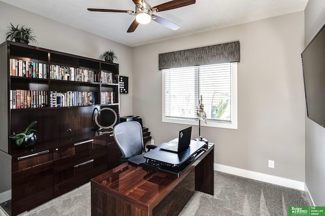 office area with a ceiling fan, baseboards, and carpet floors