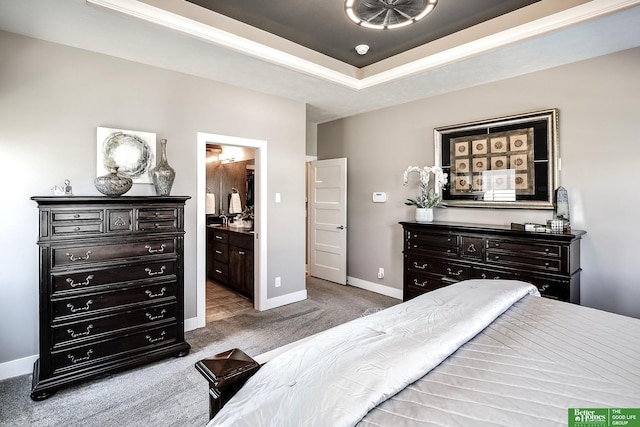 bedroom with a raised ceiling, carpet, baseboards, and connected bathroom