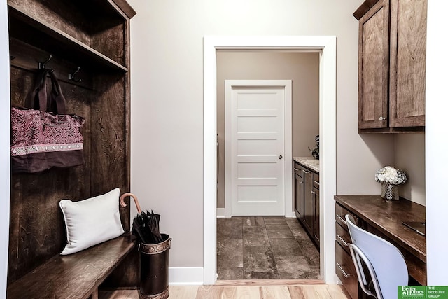 mudroom featuring stone finish floor and baseboards