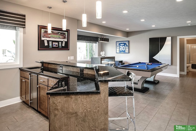 interior space with recessed lighting, baseboards, light tile patterned flooring, and a sink