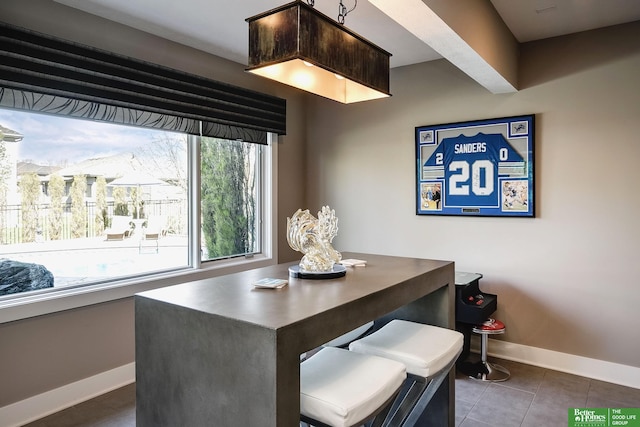 dining room featuring baseboards and tile patterned flooring