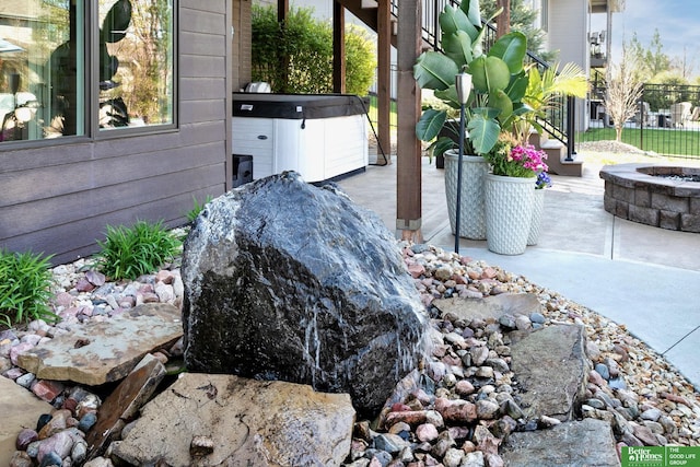 exterior details featuring a fire pit and a hot tub