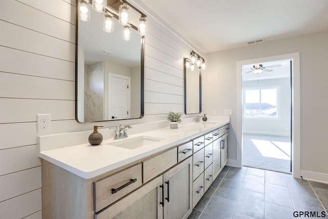 bathroom featuring a ceiling fan, a sink, visible vents, and double vanity