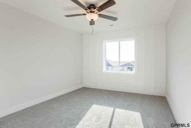 spare room featuring light carpet, a ceiling fan, visible vents, and baseboards