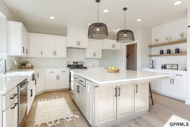 kitchen featuring recessed lighting, light wood-type flooring, stainless steel appliances, and a sink