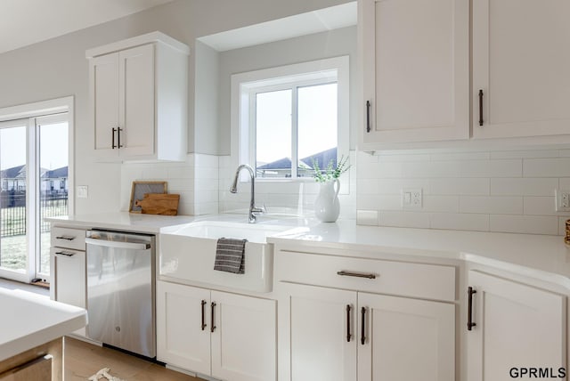 kitchen with dishwasher, white cabinets, a sink, and light countertops