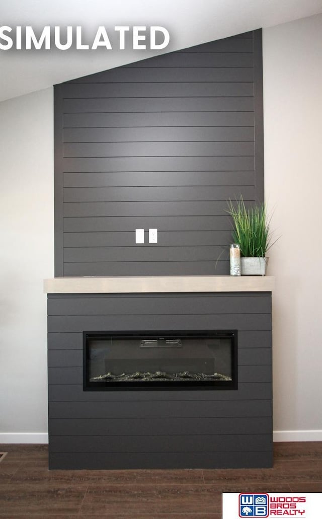 details featuring a glass covered fireplace, wood finished floors, and baseboards