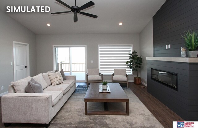 living area with a glass covered fireplace, wood finished floors, recessed lighting, and ceiling fan