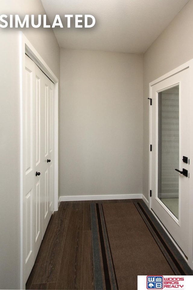hallway with dark wood finished floors and baseboards