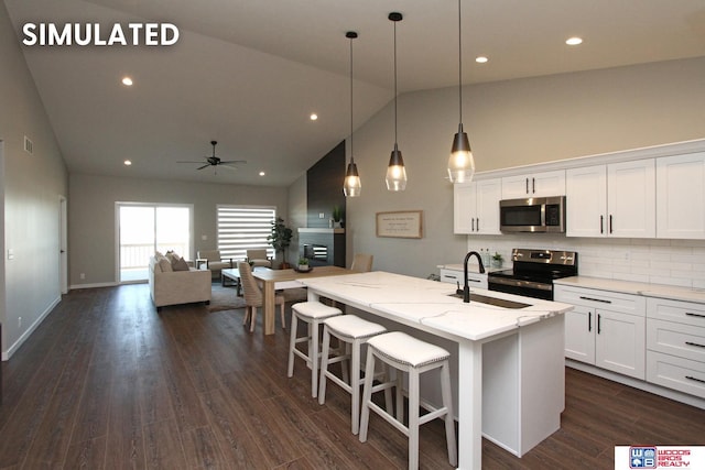 kitchen with high vaulted ceiling, a sink, ceiling fan, stainless steel appliances, and white cabinets