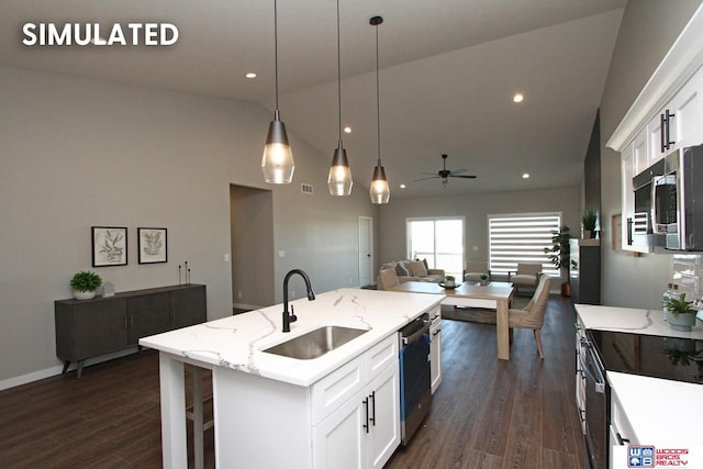 kitchen featuring a ceiling fan, a sink, stainless steel appliances, white cabinets, and dark wood-type flooring