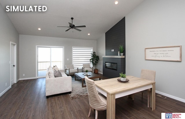 dining room with vaulted ceiling, ceiling fan, a large fireplace, baseboards, and dark wood-style floors