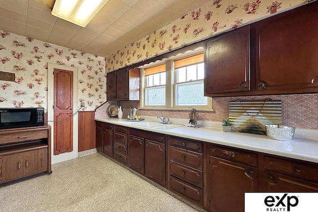 5238 S 20th St, Omaha, NE 68107 - kitchen featuring black microwave, wallpapered walls, a sink, wainscoting, and light countertops