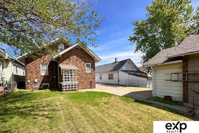 5238 S 20th St, Omaha, NE 68107 - back of property with brick siding, a patio area, and roof with shingles