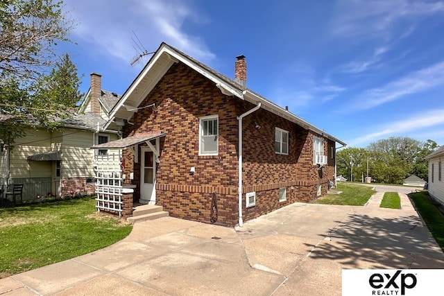 5238 S 20th St, Omaha, NE 68107 - view of front facade featuring a chimney, brick siding, and a patio