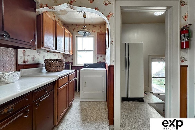 5238 S 20th St, Omaha, NE 68107 - clothes washing area with wallpapered walls, washer / clothes dryer, healthy amount of natural light, and cabinet space