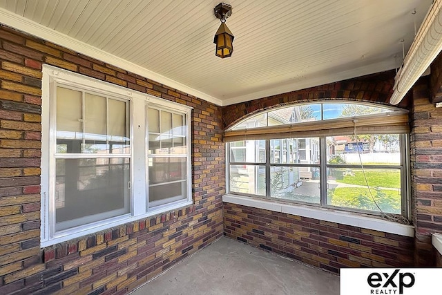 5238 S 20th St, Omaha, NE 68107 - unfurnished sunroom featuring concrete floors, brick wall, and plenty of natural light