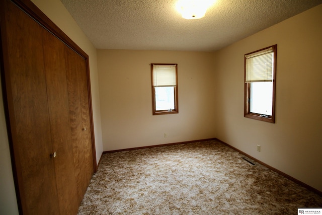 103 Francis St, Daykin, NE 68338 - unfurnished bedroom with a closet, a textured ceiling, carpet floors, and baseboards