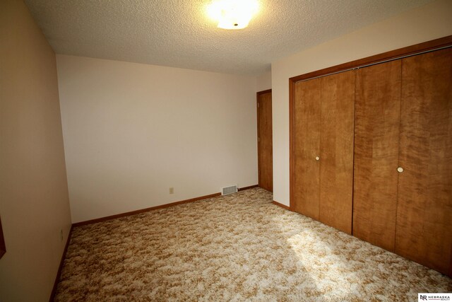 103 Francis St, Daykin, NE 68338 - unfurnished bedroom with a closet, carpet floors, and a textured ceiling