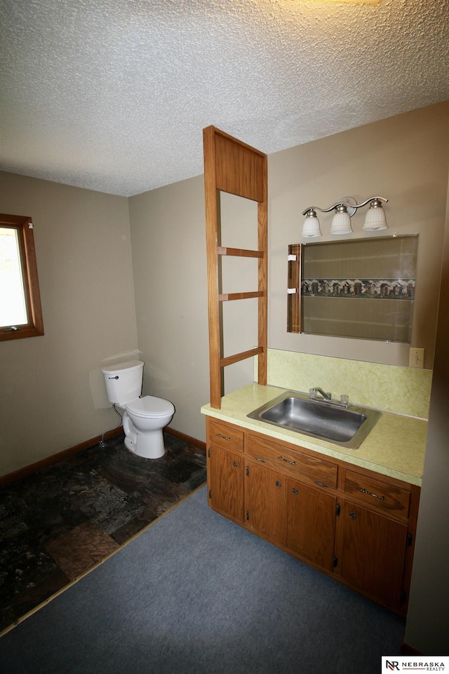 103 Francis St, Daykin, NE 68338 - bathroom featuring toilet, a textured ceiling, vanity, and baseboards