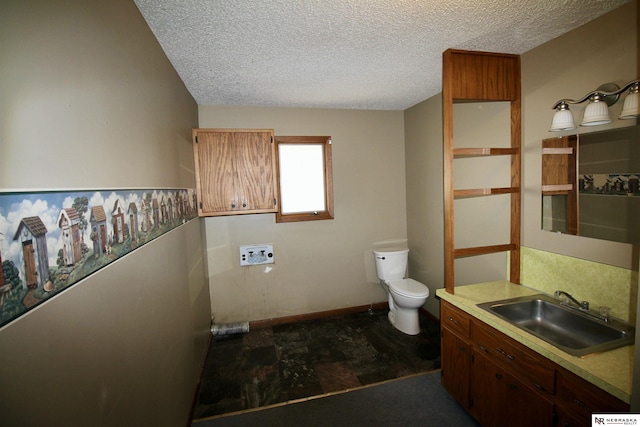 103 Francis St, Daykin, NE 68338 - bathroom with a textured ceiling, toilet, vanity, and baseboards