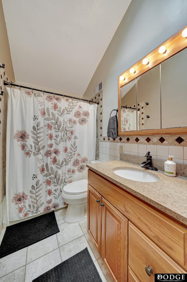 3317 N 9th St, Lincoln, NE 68521 - bathroom featuring vaulted ceiling, vanity, a shower with curtain, toilet, and visible vents