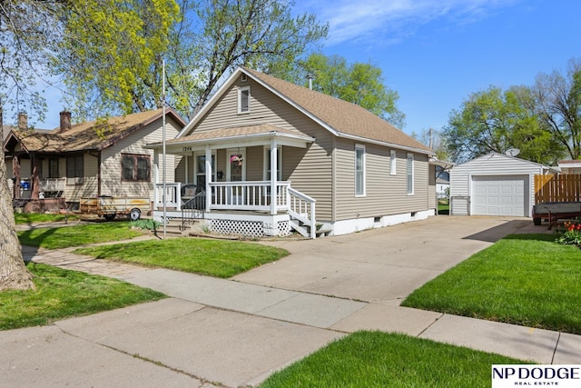 bungalow featuring a front lawn, driveway, an outbuilding, and covered porch