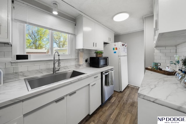 kitchen with stainless steel dishwasher, a sink, black microwave, tasteful backsplash, and white cabinetry