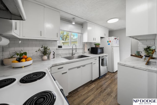 kitchen featuring decorative backsplash, a sink, white appliances, and a textured ceiling