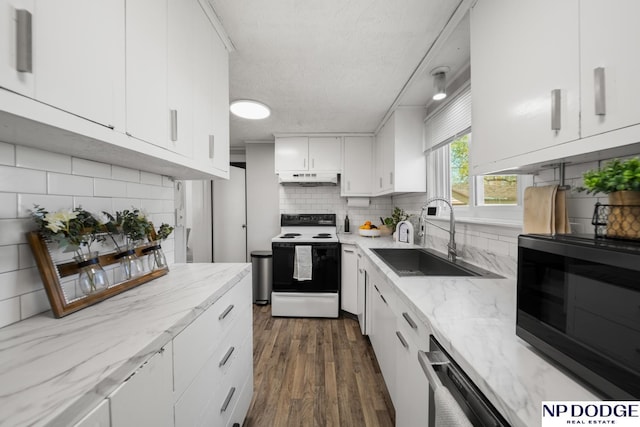kitchen with range with electric cooktop, under cabinet range hood, a sink, black microwave, and tasteful backsplash