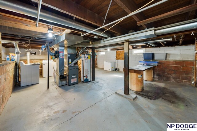 basement featuring separate washer and dryer, heating unit, and gas water heater