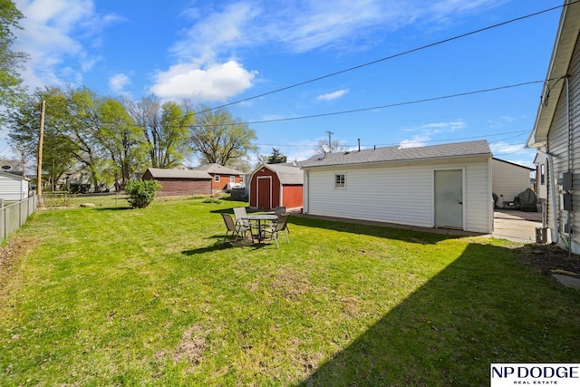 view of yard featuring fence, an outbuilding, and a storage shed