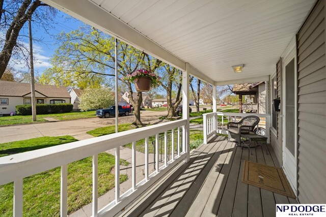 wooden terrace with a porch and a residential view