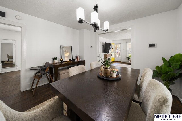 dining room with a chandelier, wood finished floors, and baseboards