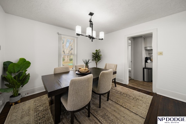 dining area with an inviting chandelier, a textured ceiling, dark wood-style floors, and baseboards