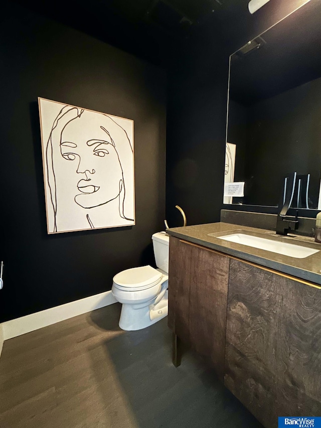 half bathroom featuring vanity and toilet