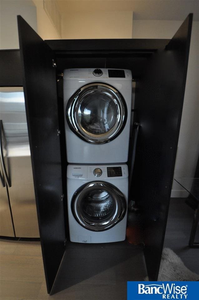 washroom with stacked washing maching and dryer and laundry area