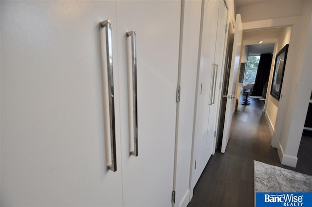 hall with baseboards and dark wood-style floors