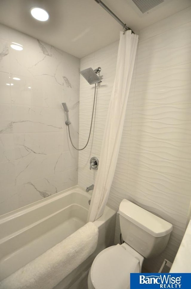 bathroom featuring shower / bath combo, toilet, visible vents, and tile walls