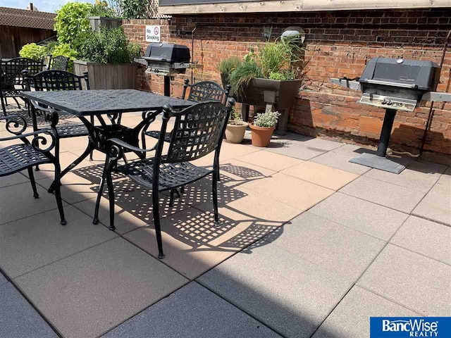 view of patio featuring fence, outdoor dining space, exterior kitchen, and area for grilling