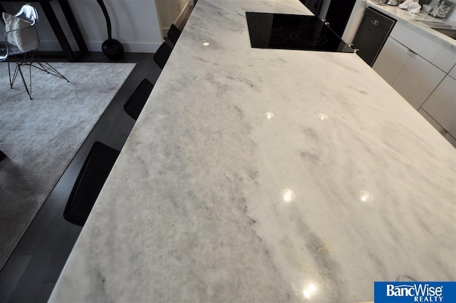 room details featuring white cabinets, modern cabinets, light countertops, and stovetop