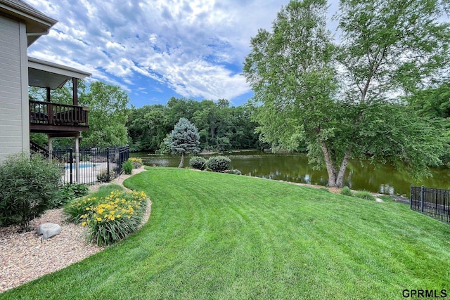 view of yard with a fenced in pool, a water view, and fence