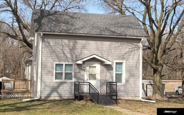 view of front facade with an outdoor structure and a front yard