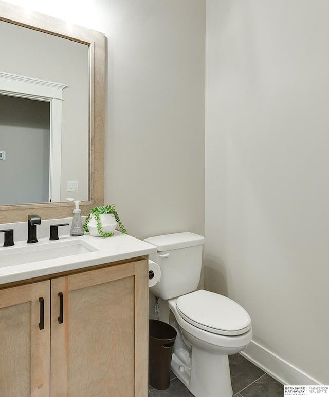 bathroom featuring tile patterned floors, vanity, toilet, and baseboards
