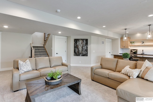 living room with recessed lighting, stairs, light carpet, and baseboards