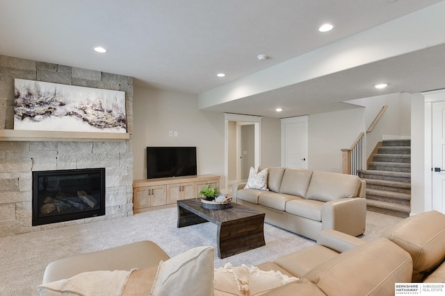 carpeted living area with recessed lighting, stairs, and a large fireplace