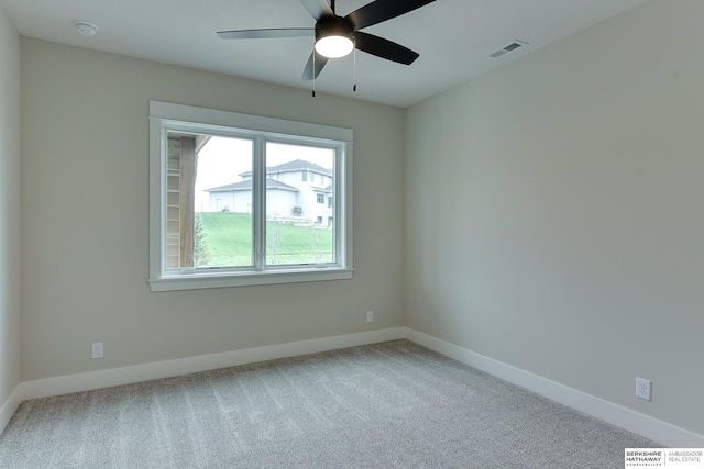 carpeted empty room featuring a ceiling fan, visible vents, and baseboards