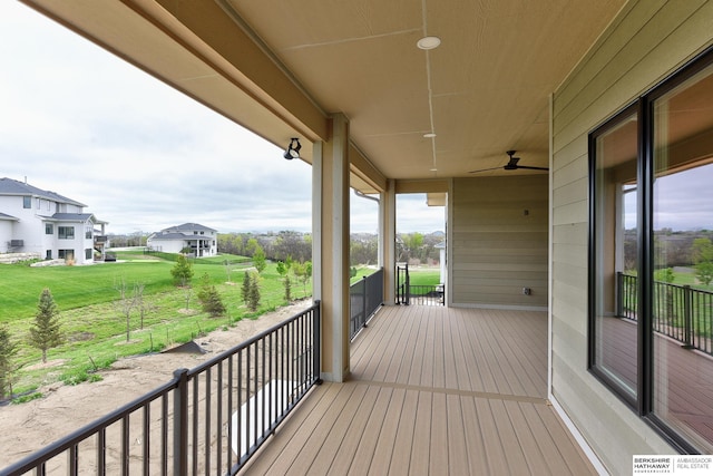 wooden deck with a residential view and a ceiling fan