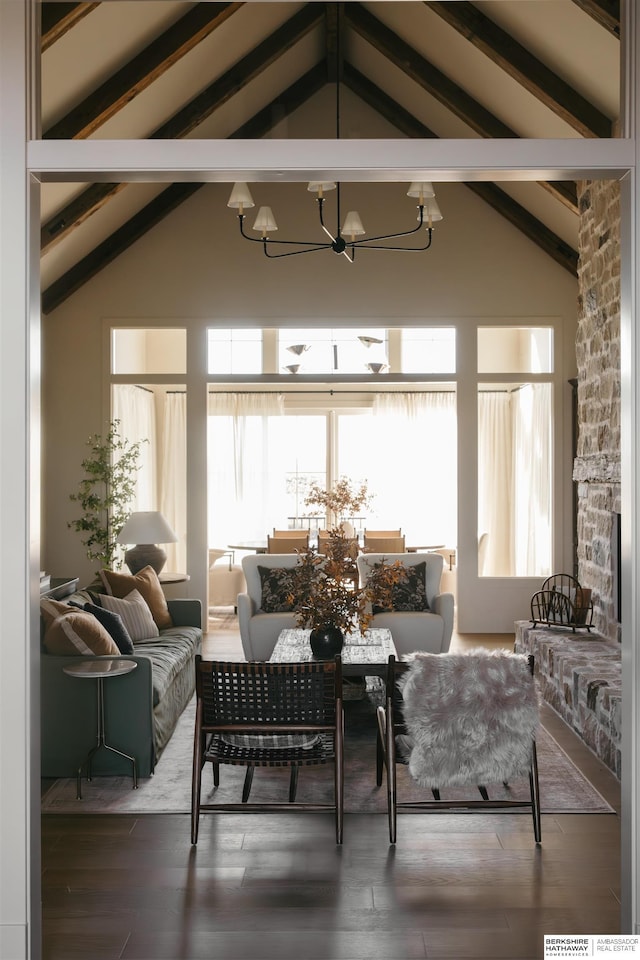living area with wood finished floors, beam ceiling, a chandelier, and high vaulted ceiling