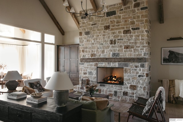 living area with a stone fireplace, wood finished floors, beam ceiling, a chandelier, and high vaulted ceiling